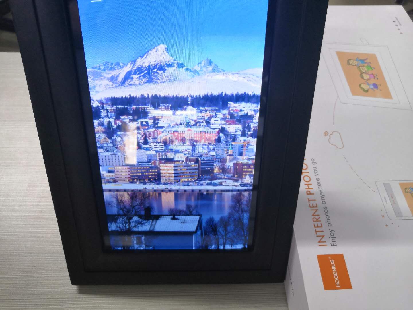 Black digital frame display vertical picture on desktop with HDgenius box